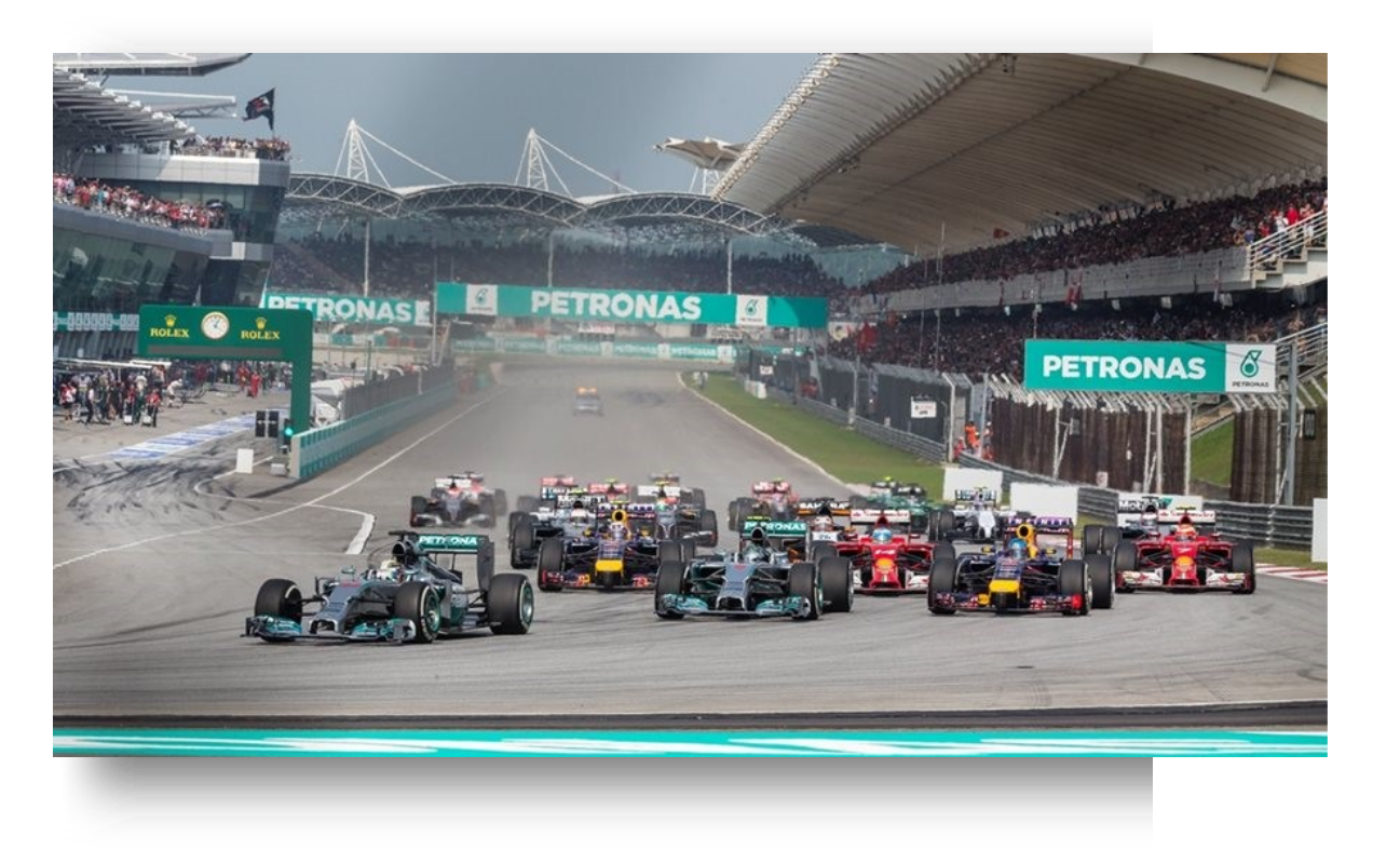 Aerial view of Sepang F1 Circuit with racing cars on track and crowded grandstands